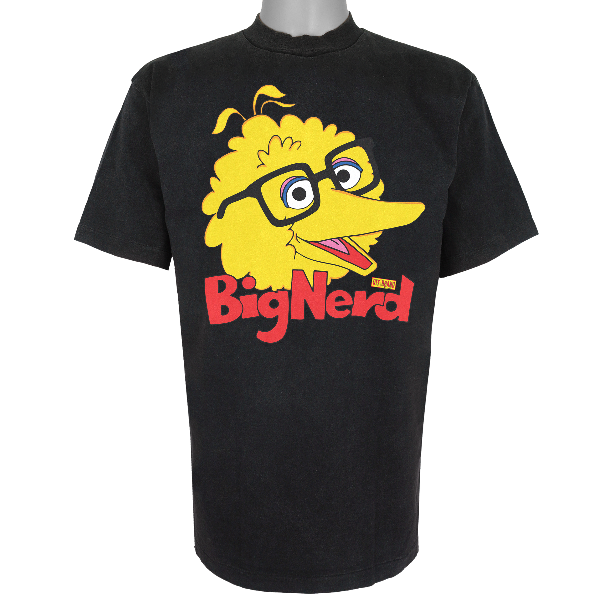 Big Nerd parody graphic inspired by nostalgic children's TV culture, featuring yellow bird artwork with thick-rimmed glasses inside a yellow price tag logo on a Basic Black t-shirt.
