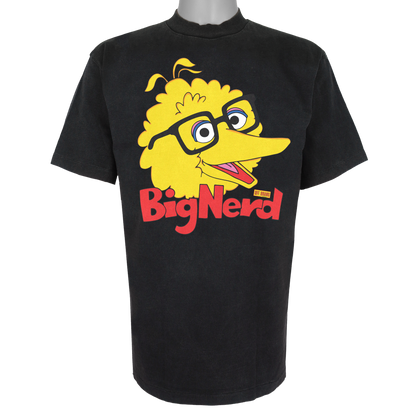 Big Nerd parody graphic inspired by nostalgic children's TV culture, featuring yellow bird artwork with thick-rimmed glasses inside a yellow price tag logo on a Basic Black t-shirt.
